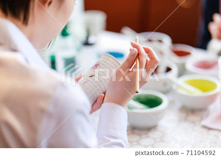A young woman experiencing pottery painting A young woman experiencing pottery painting 71104592