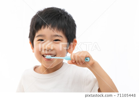 Boy brushing his teeth happily Boy brushing his teeth happily 71105448