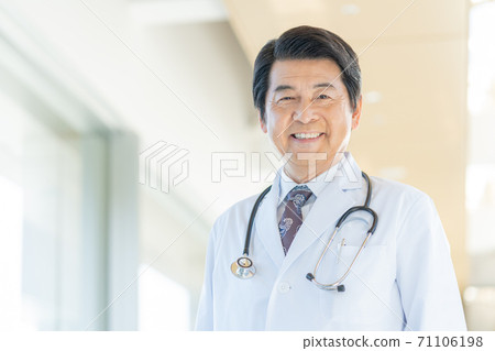 A smiling middle-aged doctor standing in the hospital corridor 71106198