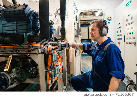 Marine engineer officer controlling vessel enginesand propulsion in engine control room ECR Marine engineer officer controlling vessel enginesand propulsion in engine control room ECR 71106307