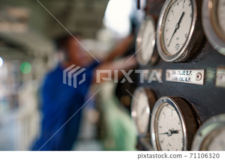Marine engineer officer controlling vessel enginesand propulsion in engine control room ECR Marine engineer officer controlling vessel enginesand propulsion in engine control room ECR 71106320