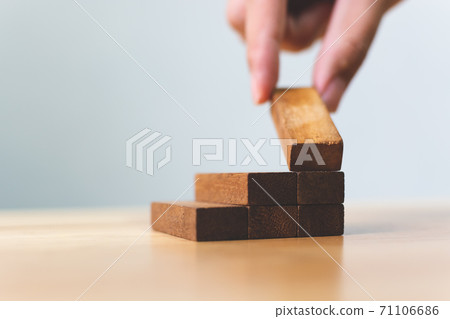 Hand arranging wood block stacking as step stair Hand arranging wood block stacking as step stair 71106686