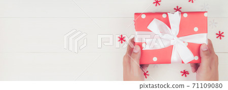 Hand of man holding gift giving on wooden table in Christmas day or holiday. Hand of man holding gift giving on wooden table in Christmas day or holiday. 71109080