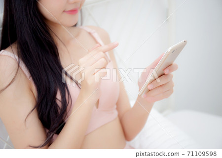 Closeup beautiful young asian woman sexy in underwear chatting on mobile phone. 71109598