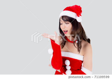 Beautiful portrait young asian woman Santa costume presenting empty plam with happy. 71109599