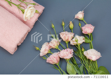 Soft terry towels with bouquet of flowers on gray background 71110011