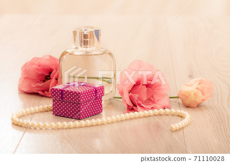 Bottle of women perfume with gift box and flowers on pink background 71110028