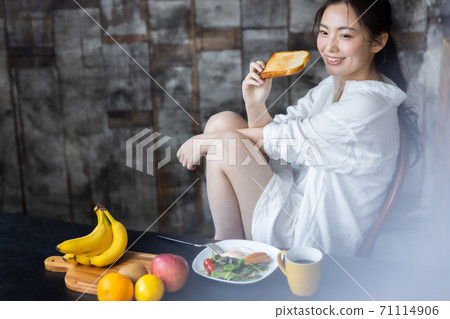 A woman eating breakfast A woman eating breakfast 71114906