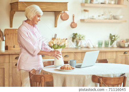 Smiling senior lady spending her morning at home Smiling senior lady spending her morning at home 71116045