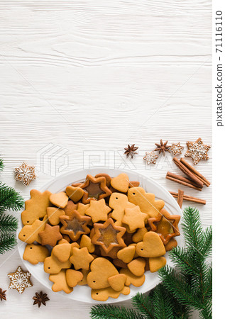 Plate full of freshly baked Christmas gingerbread ready to decorate with icing on white wooden background. Copy space Plate full of freshly baked Christmas gingerbread ready to decorate with icing on white wooden background. Copy space 71116110