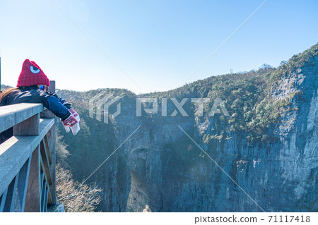 Female tourist enjoy beautiful scenery on Tianmen mountain, China Female tourist enjoy beautiful scenery on Tianmen mountain, China 71117418