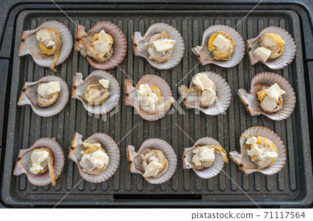 Grilling scallops and cheese on electric pan at home 71117564