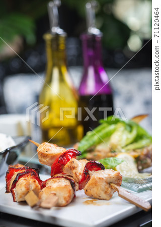 Traditional, oriental and Asian kebabs on a wooden skewer of grilled chicken pieces boiled rice as a garnish. 71120464