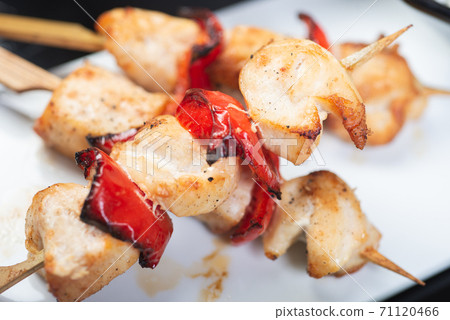 Traditional, oriental and Asian kebabs on a wooden skewer of grilled chicken pieces boiled rice as a garnish. 71120466