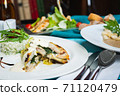 Fillet of white fish sea bass, cod stuffed with greens and rice on the table in the restaurant. 71120479