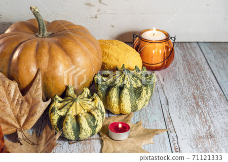 Thanksgiving background, composition with pumpkins, dry autumn leaves, candles on wooden background. Thanksgiving background, composition with pumpkins, dry autumn leaves, candles on wooden background. 71121333