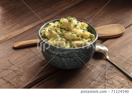 Pomme puree, a photo of a bowl of mashed potatoes with herbs on a rustic background with a wooden spoon Pomme puree, a photo of a bowl of mashed potatoes with herbs on a rustic background with a wooden spoon 71124590