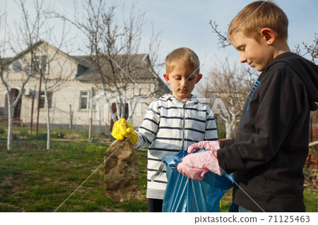 Two little boys in park collect plastic bottles Two little boys in park collect plastic bottles 71125463