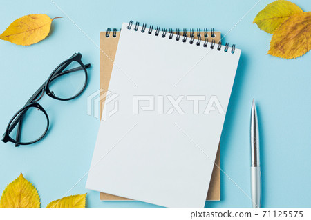notebook on blue table top view, with blank page 71125575