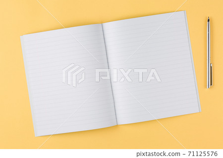 notebook with black pen on yellow background 71125576