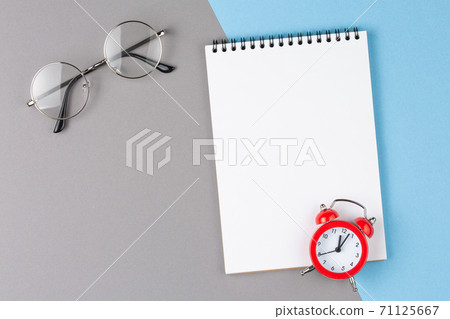 notebook with red alarm clock on blue 71125667