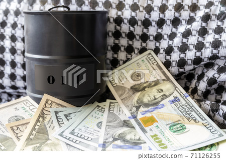 Barrel of oil on a background, american dollars and arabian background. Word on barrel is Oil. Falling trend of barrel price decrease of earning and global economics . Selective focus. Barrel of oil on a background, american dollars and arabian background. Word on barrel is Oil. Falling trend of barrel price decrease of earning and global economics . Selective focus. 71126255