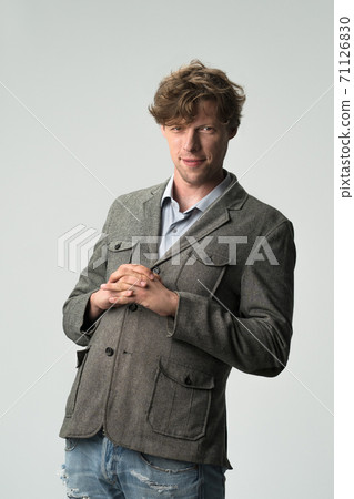 Funny man with arms folded on chest making big tummy. Ambition concept. Young Caucasian male model wearing casual isolated on white background. 71126830