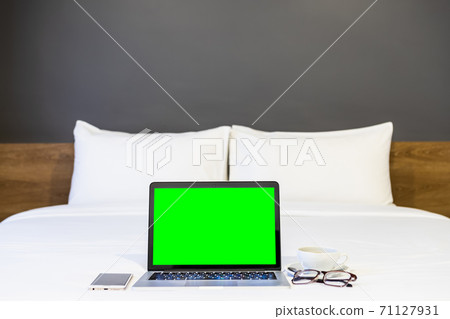 Laptop computer with blank white screen with smartphone,coffee cup and spectacles on white bed decoration in hotel bedroom interior background,Work and business in leisure with travel in the holiday. Laptop computer with blank white screen with smartphone,coffee cup and spectacles on white bed decoration in hotel bedroom interior background,Work and business in leisure with travel in the holiday. 71127931