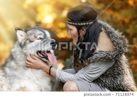 Woman with an Alaskan Malamute dog in the autumn forest 71128974
