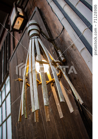 a historic lamp with a modern light-bulb on the wall of the house. a historic lamp with a modern light-bulb on the wall of the house. 71128986