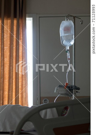 A stand with drip bag beside the bed at hospital.  71128993