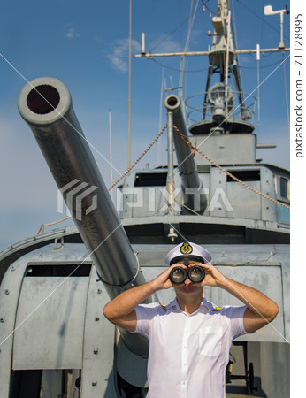 Captain of warship standing beside cannons and looking ahead.  71128995