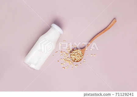 Bottle of non dairy oat milk on pink background 71129241