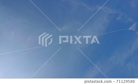 A straight line of contrails in the blue sky 71129580