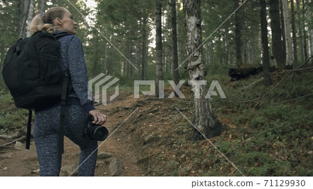 Traveler photographing scenic view in forest. One caucasian woman shooting nice magic look. Girl take photo video on dslr mirrorless camera. Traveler photographing scenic view in forest. One caucasian woman shooting nice magic look. Girl take photo video on dslr mirrorless camera. 71129930