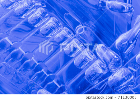 Glass medical ampoule vial for injection. Medicine is liquid sodium chloride with of aqueous solution in ampulla. Close up. Bottles ampule multicolor. Glass medical ampoule vial for injection. Medicine is liquid sodium chloride with of aqueous solution in ampulla. Close up. Bottles ampule multicolor. 71130003
