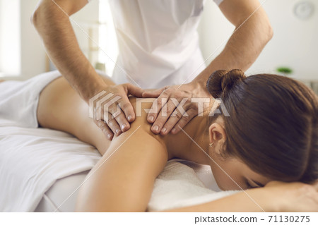 Hands of professional chiropractor or masseur making massage of back and shoulders for woman 71130275