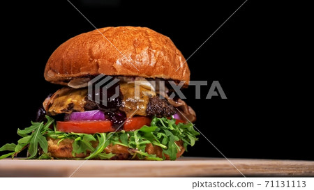 Craft burger is cooking on black background. Consist: sauce, arugula, tomato, onion, bacon, currant sauce, ricotta cheese, air bun and marble meat. 71131113