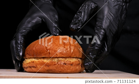 Craft burger is cooking on black background. Consist: sauce, arugula, tomato, onion, bacon, currant sauce, ricotta cheese, air bun and marble meat. 71131124