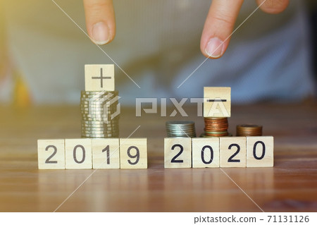 business man pointing his fingers to stack of coins and plus sign ,minus sign world economic. business concept. business man pointing his fingers to stack of coins and plus sign ,minus sign world economic. business concept. 71131126
