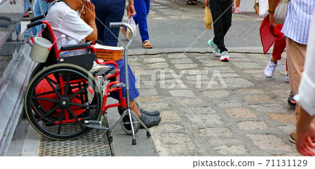 disabled man sitting on wheelchair waiting for donations from people passed disabled man sitting on wheelchair waiting for donations from people passed 71131129