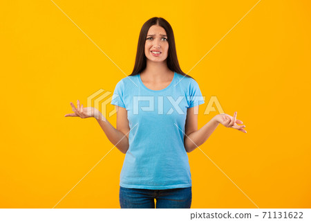 Confused puzzled young woman shrugging at studio Confused puzzled young woman shrugging at studio 71131622