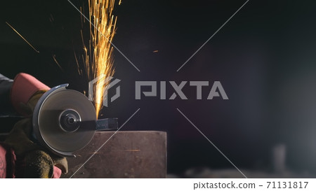 Forge workshop. Smithy manual production. Close up details of sparks, industrial worker using angle grinder and cutting steel. Forge workshop. Smithy manual production. Close up details of sparks, industrial worker using angle grinder and cutting steel. 71131817
