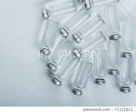 Glass medical ampoule vial for injection. Medicine is dry white drug penicillin powder or liquid with of aqueous solution in ampulla. Close up. Glass medical ampoule vial for injection. Medicine is dry white drug penicillin powder or liquid with of aqueous solution in ampulla. Close up. 71131821