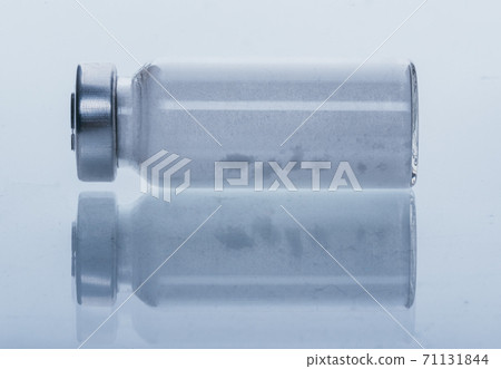 Glass medical ampoule vial for injection. Medicine is dry white drug penicillin powder or liquid with of aqueous solution in ampulla. Close up. Glass medical ampoule vial for injection. Medicine is dry white drug penicillin powder or liquid with of aqueous solution in ampulla. Close up. 71131844