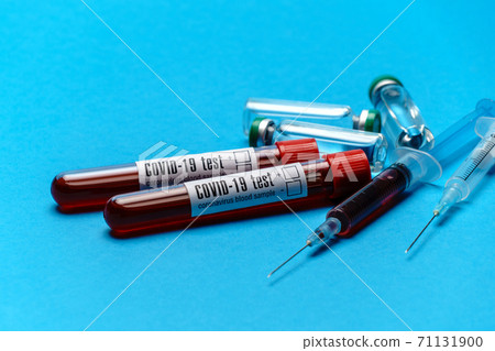 Syringe, test tubes with blood samples and ampoules with medicines or vaccine over blue background 71131900