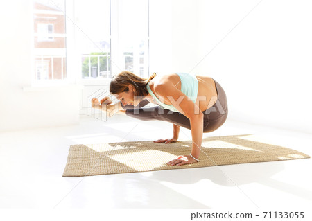 Flexible woman doing yoga at home 71133055