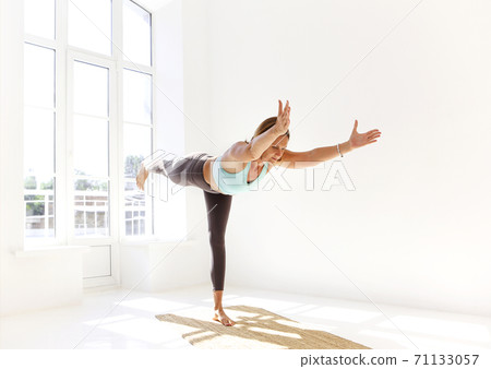Flexible woman doing yoga at home 71133057