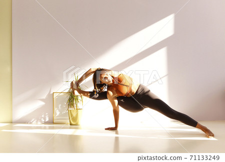 Flexible woman doing yoga at home 71133249
