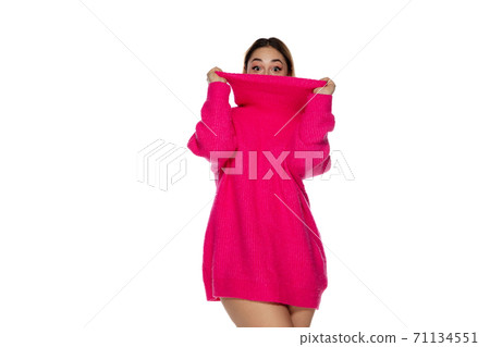 Beautiful young woman in bright pink comfortable sweater, long sleeve isolated on white studio background 71134551